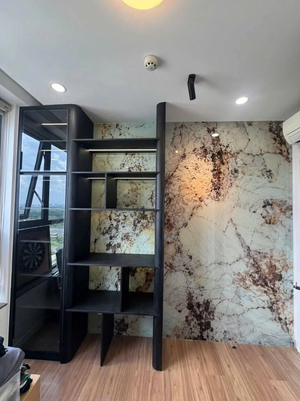 Kệ khung đen và vách đá Kệ trang trí khung đen phân chia không gian cạnh vách ốp vân đá căn hộ Precia
