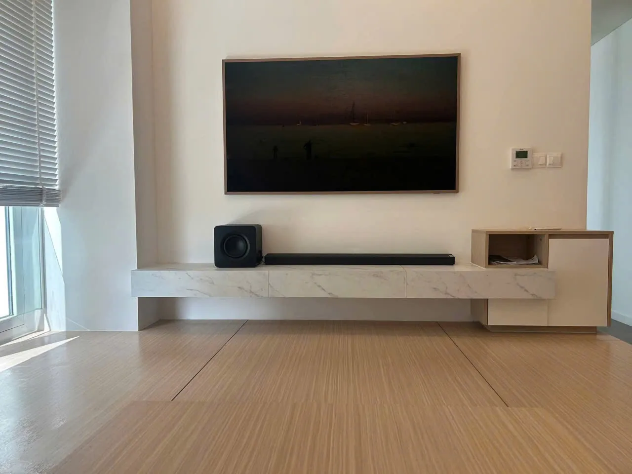 Kệ tivi treo tường mặt vân đá kết hợp hộc gỗ trong phòng khách căn hộ Berkley