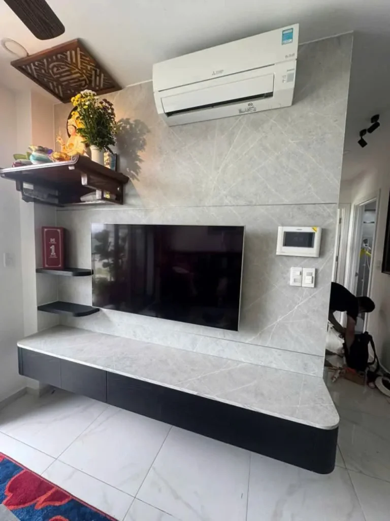 Kệ tivi treo mặt vân đá, vách ốp đá và kệ thờ treo trong phòng khách căn hộ Precia