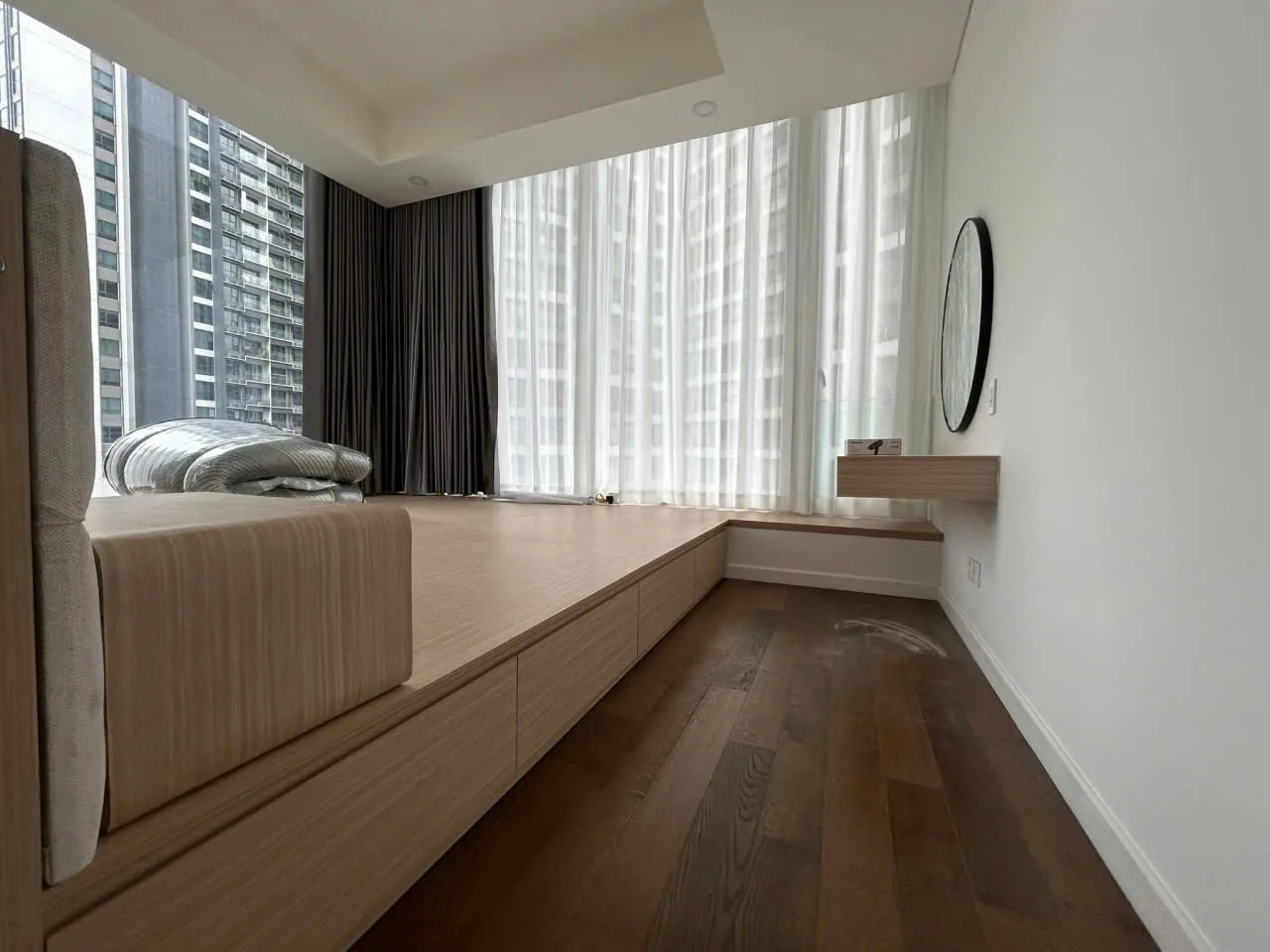 Phòng ngủ căn hộ Berkley với sàn bục gỗ và đầu giường bọc nệm
