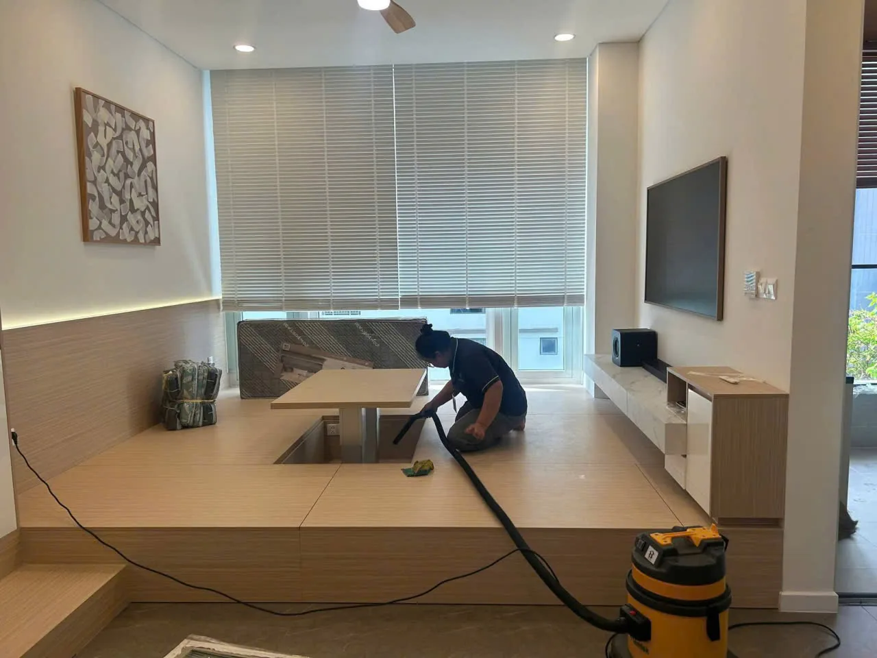 Thợ Vạn Cường vệ sinh sau khi lắp đặt sàn bục tatami phòng khách căn hộ Berkley