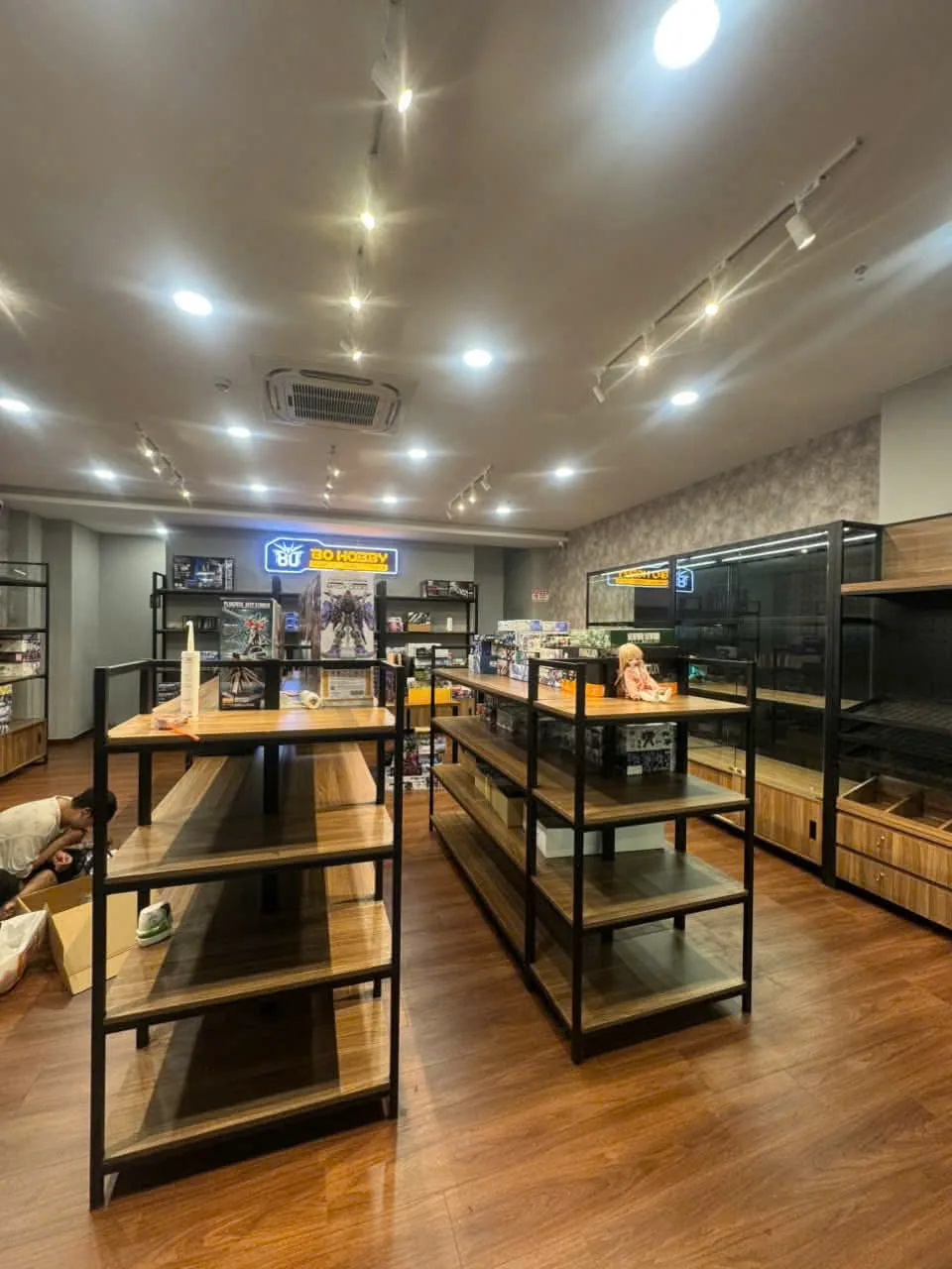 Tổng quan shop mô hình với hệ kệ trưng bày khung sắt đen kết hợp mặt gỗ