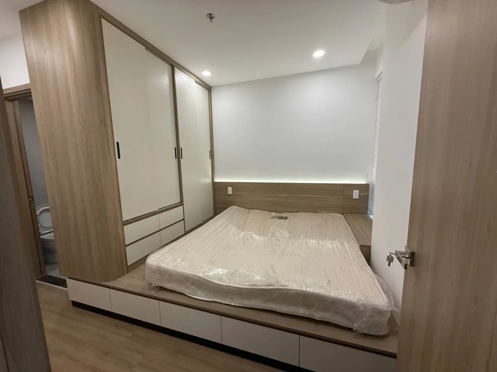 Tủ quần áo kịch trần cánh trắng và giường bục gỗ có đèn LED hắt đầu giường – căn hộ Eastmark City