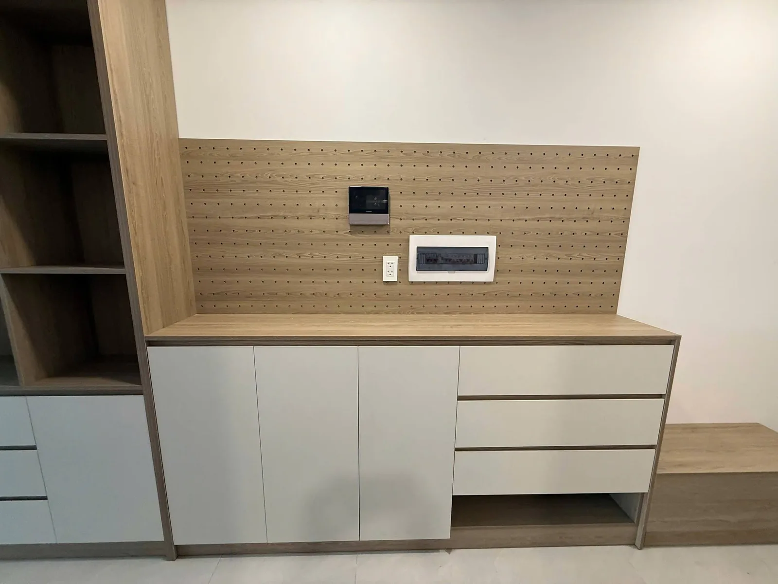 Tủ kệ thấp kết hợp vách pegboard gỗ Tủ kệ thấp cánh trắng kết hợp vách pegboard vân gỗ sồi trong căn hộ Eastmark City