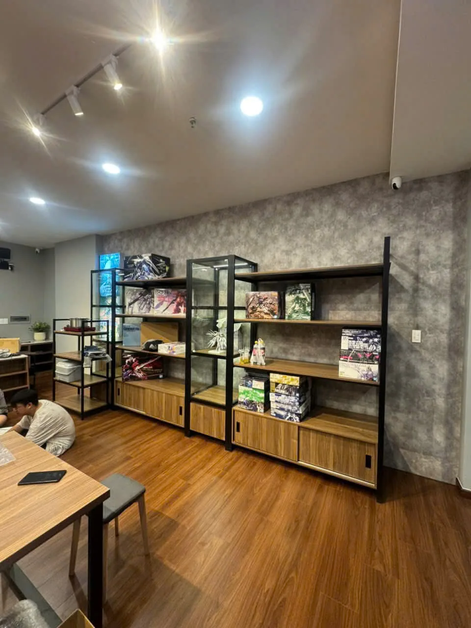 Vách kệ trưng bày khung sắt mặt gỗ kết hợp tủ kính trong shop mô hình